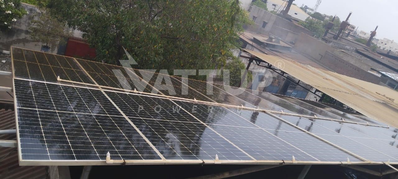 Cleaned Solar Panels After Using WattUp Cleaner, Mounted on a Rooftop, Surrounded by Trees and Buildings